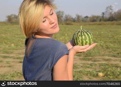 Girl with a watermelon in her hand. Search for watermelons in the field of melons. Found a watermelon.. Girl with a watermelon in her hand. Search for watermelons in the field of melons. Found a watermelon