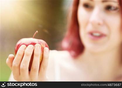 Girl with apple. Portrait of girl with red apple in summer park