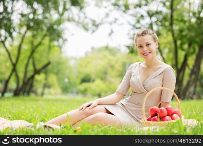 Girl with apple. Young pretty woman in summer park with apple