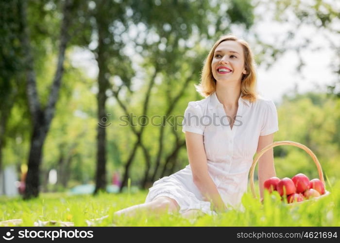 Girl with apple. Young pretty woman in summer park with apple