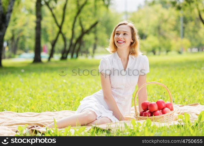 Girl with apple. Young pretty woman in summer park with apple