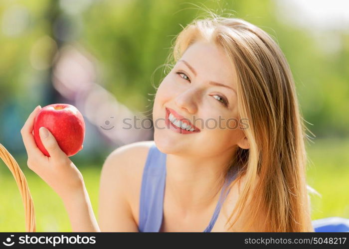 Girl with apple. Young pretty woman in summer park with apple