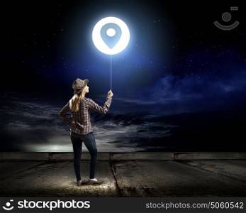 Girl with balloon. Young woman in casual standing with back and holding glowing balloon