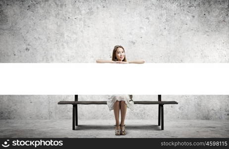 Girl with banner. Young asian woman sitting on bench with blank banner