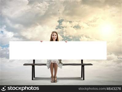 Girl with banner. Young asian woman sitting on bench with blank banner