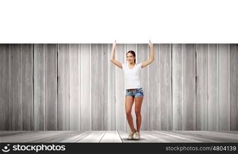 Girl with banner. Young pretty girl in shorts holding white blank banner