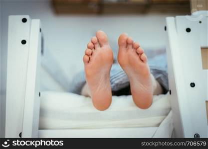 Girl with Barenaked feed is lying in her bunk bed, morning