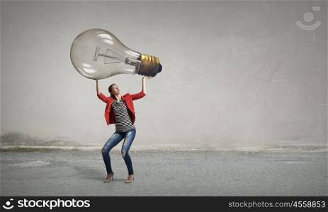 Girl with big glass bulb. Young girl in red jacket pushing glass light bulb