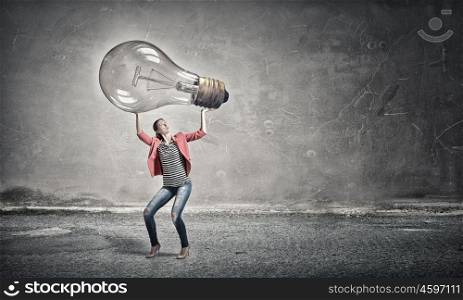 Girl with big glass bulb. Young woman lifting glass light bulb above head