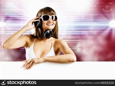 Girl with blank banner. Young woman in white bikini wearing headphones. Place for text