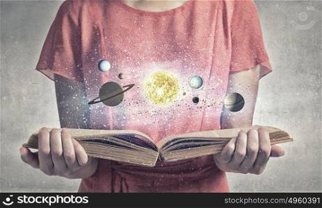 Girl with book. Close up of woman with book exploring planets of sun system