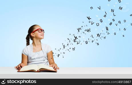 Girl with book. Cute girl of school age in glasses reading book