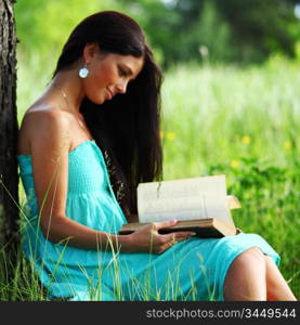 girl with book under big tree