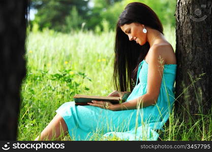 girl with book under big tree