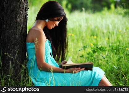 girl with book under big tree