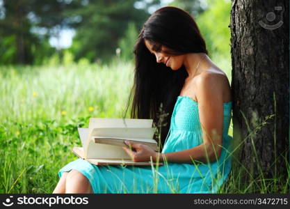 girl with book under big tree