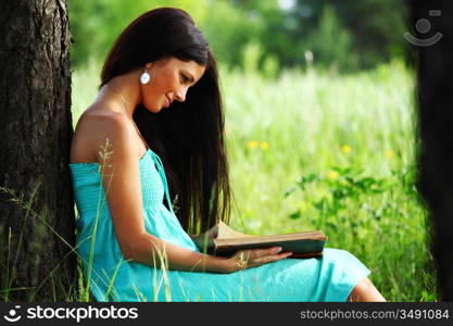 girl with book under big tree