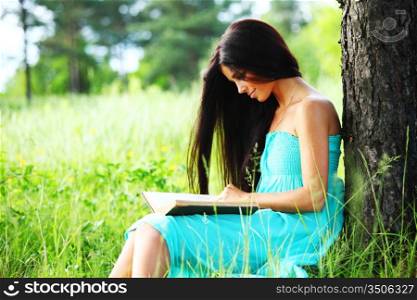 girl with book under big tree