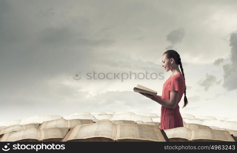 Girl with book. Young emotional woman in red dress with book in hands