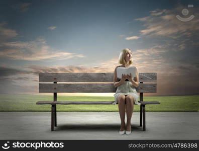 Girl with book. Young pretty woman sitting on bench and reading book