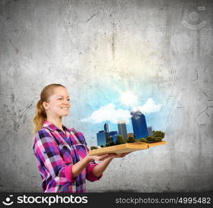 Girl with book. Young woman in casual holding opened book with city model