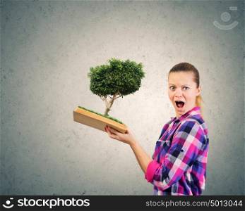 Girl with book. Young woman in casual holding opened book with green tree