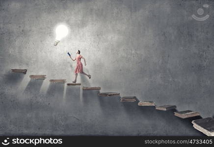 Girl with book. Young woman in red dress running with book in hand