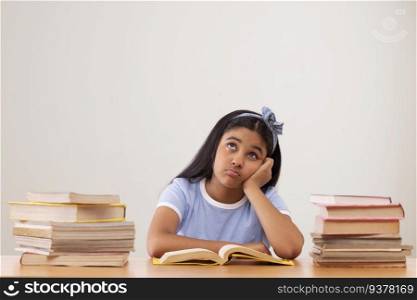 Girl with bored expression sitting between two stacks of books 