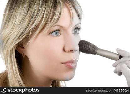 Girl with brush painting her face on white