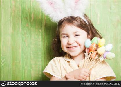 Girl with bunny ears and little eggs. Easter celebration. Girl with bunny ears
