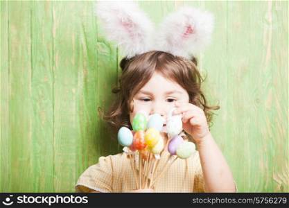 Girl with bunny ears and little eggs. Easter celebration. Girl with bunny ears