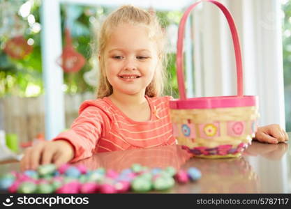 Girl With Chocolate Easter Eggs And Basket At Home