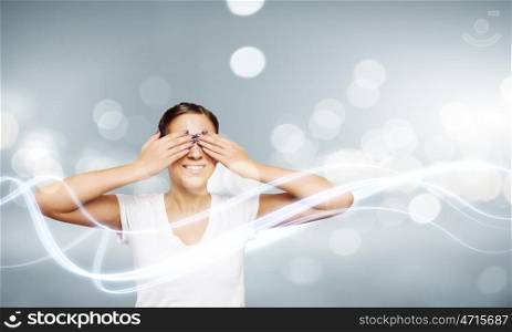 Girl with closed eyes. Young woman in white shirt closing eyes with palms