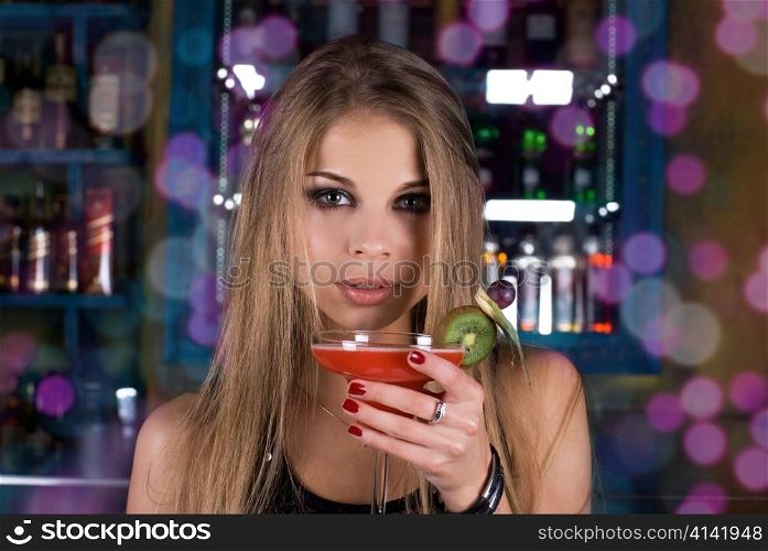 Girl with cocktail on dancing people background
