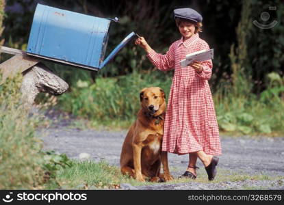Girl with dog retrieving letters from mailbox