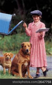 Girl with dogs retrieving letters from mailbox