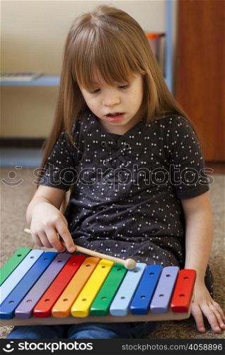 girl with down syndrome playing with xylophone