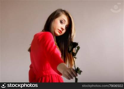 girl with dried rose in hand gray background