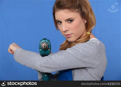 Girl with drill on blue background