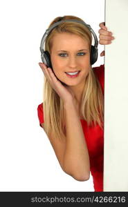 Girl with earphones hidden behind a panel