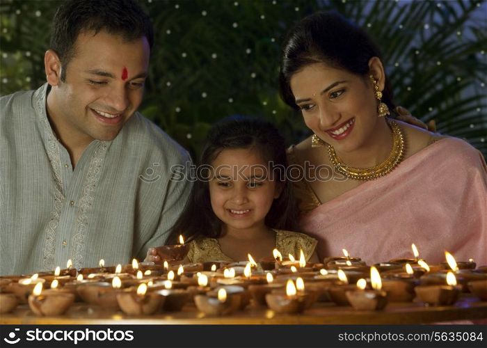 Girl with family arranging diyas
