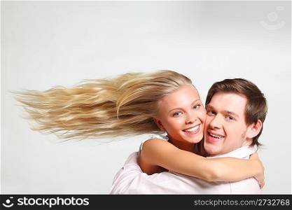 girl with flying hair embraces young man