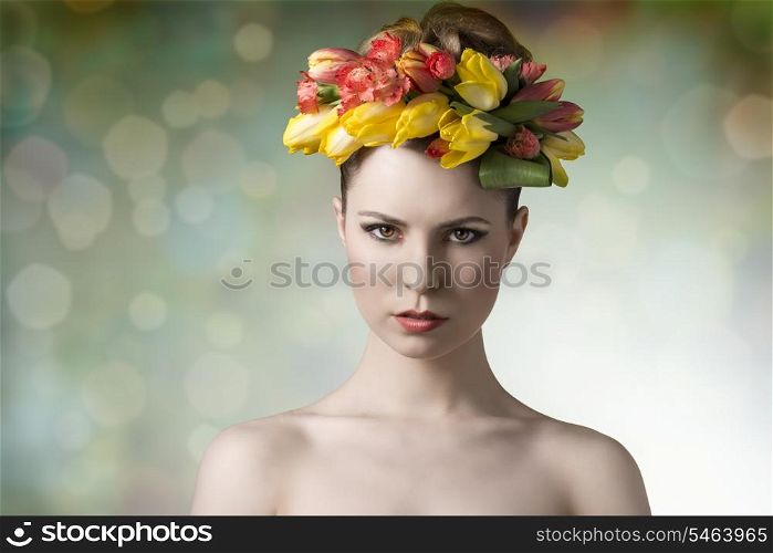 girl with fresh look wearing floral garland on her head and posing in spring concept portrait with naked shoulders and colorful make-up