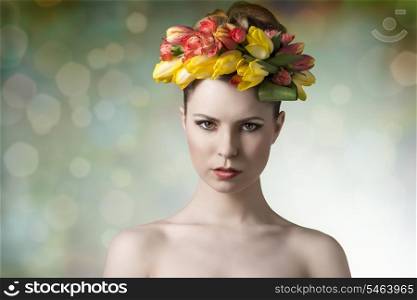 girl with fresh look wearing floral garland on her head and posing in spring concept portrait with naked shoulders and colorful make-up