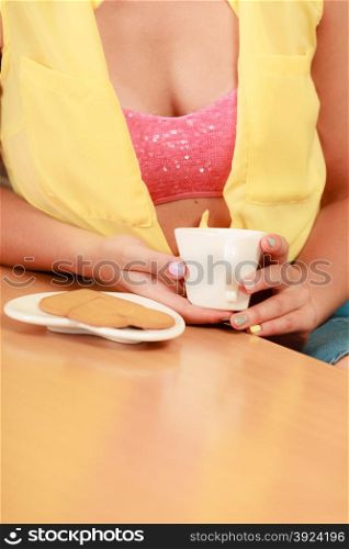 Girl with gingerbread cookies and tea coffee.. Closeup of girl with heart shape gingerbread cookies and tea or coffee at home. Retro woman with hot beverage relaxing in kitchen.
