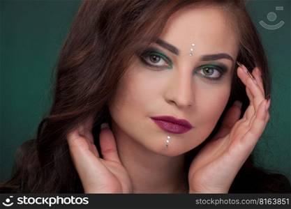 Girl with green eye shadows, make-up, facial stones crystals