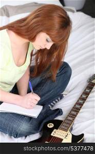 Girl with guitar composing a song