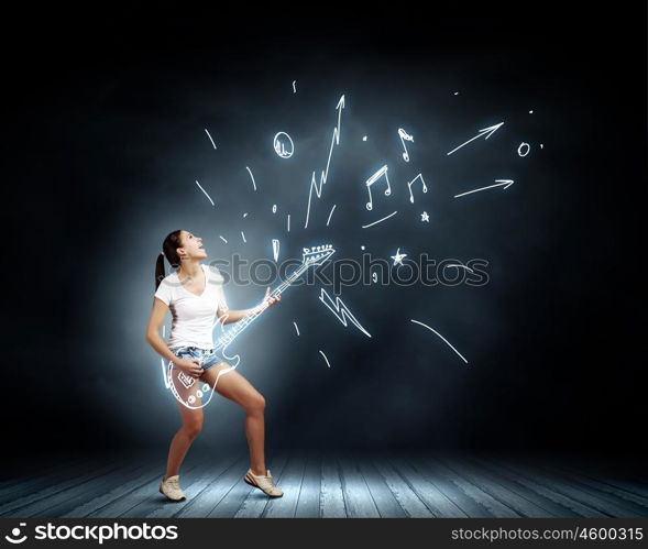 Girl with guitar. Young girl in shorts playing on imaginary guitar