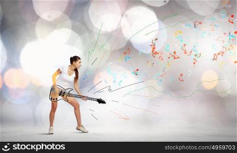 Girl with guitar. Young girl in shorts playing on imaginary guitar