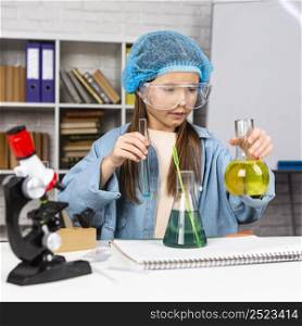 girl with hair net doing science experiments